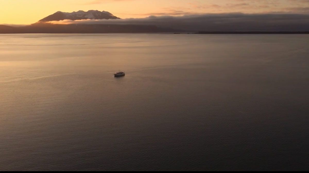 Alaska small cruise ship with sunset